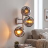 Moderne wandlamp Koyoto met drie ronde rook- en chroomkleurige kappen naast de bank