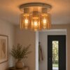 Brilliant plafondlamp Lyska met Scandinavische cilindervormige amberkleurige glazen kappen